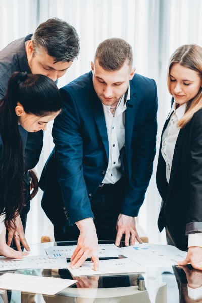 a team of 4 people gathered around a table discussing clinical trial project management